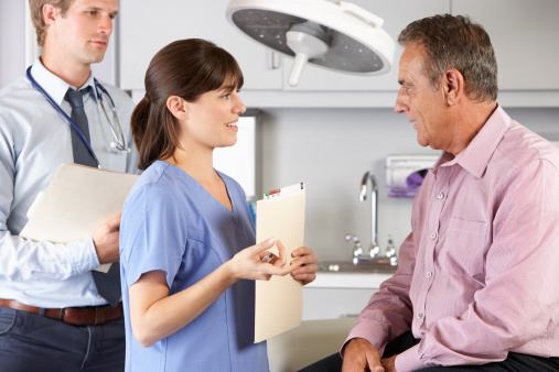 A nurse and a doctor discuss radiation therapy options with a patient with liver cancer.