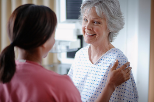 A female patient speaks with a medical professional prior to a liver transplant.