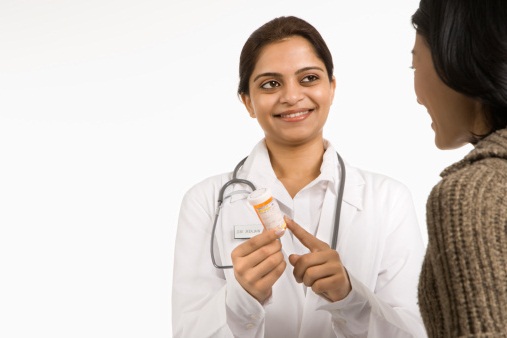 A female pharmacist informs a patient on how to properly take targeted therapy medication.